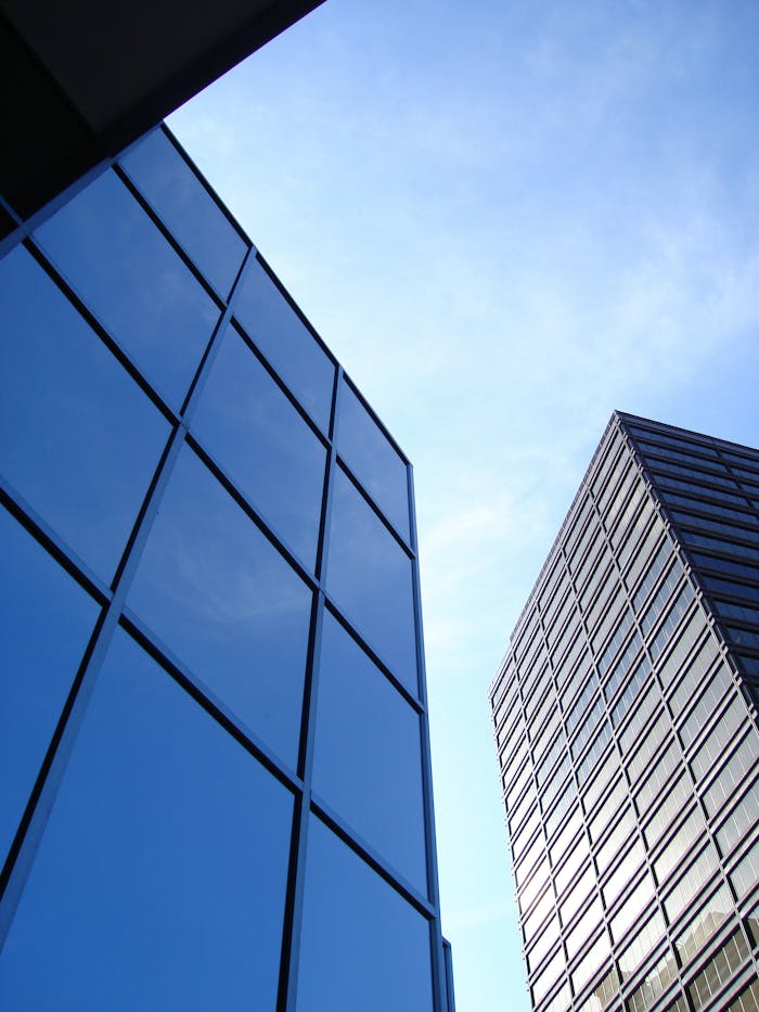 Tall glass skyscrapers reflecting the sky, perfect for business or architecture themes.